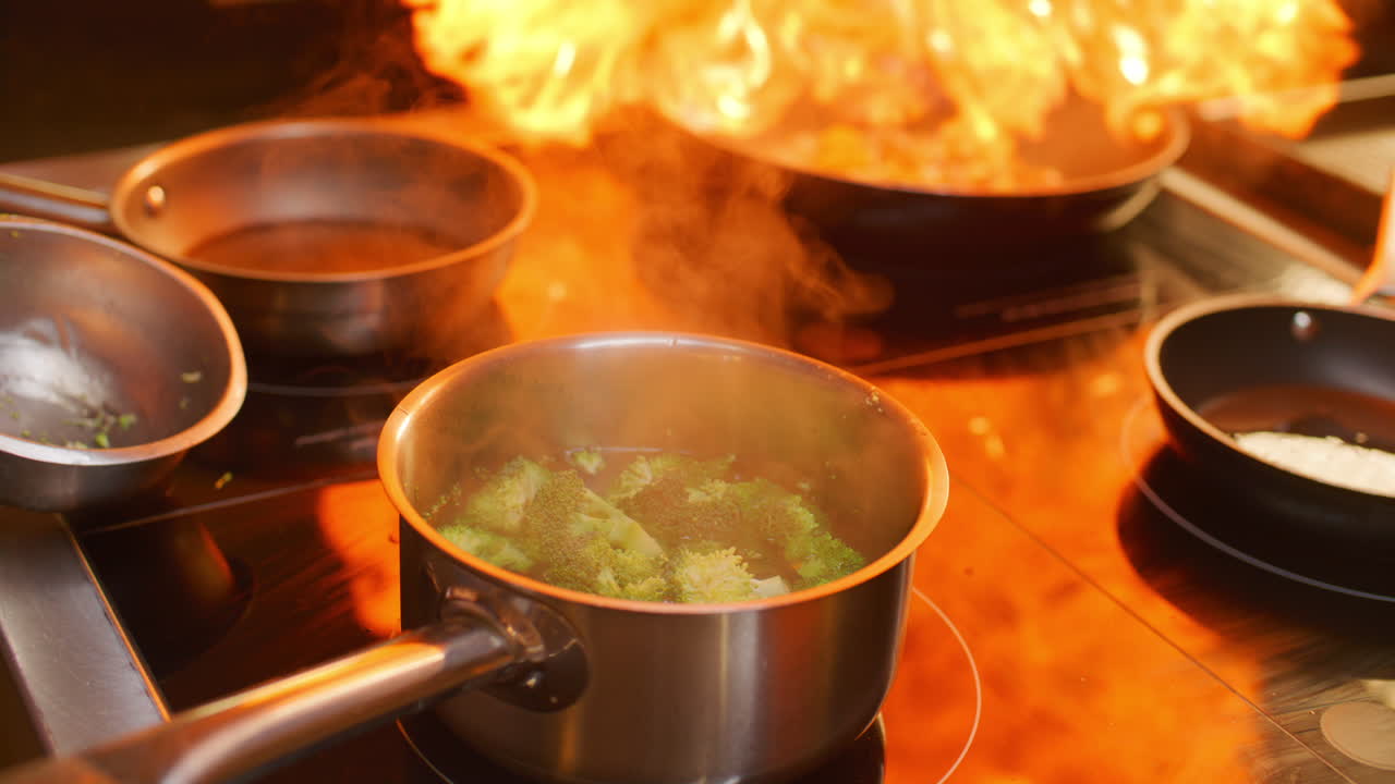 Zbliżenie na szefa kuchni gotującego świeże brokuły w garnku na kuchence w kuchni restauracyjnej