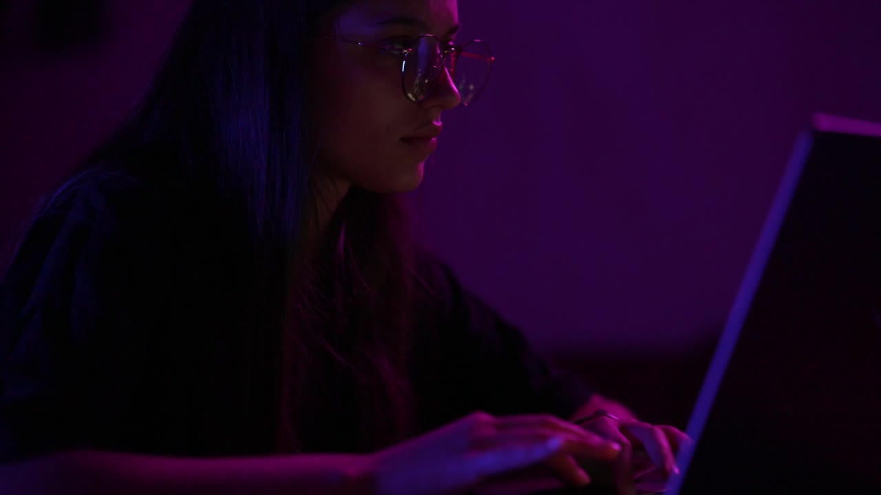 Woman working on a laptop at night