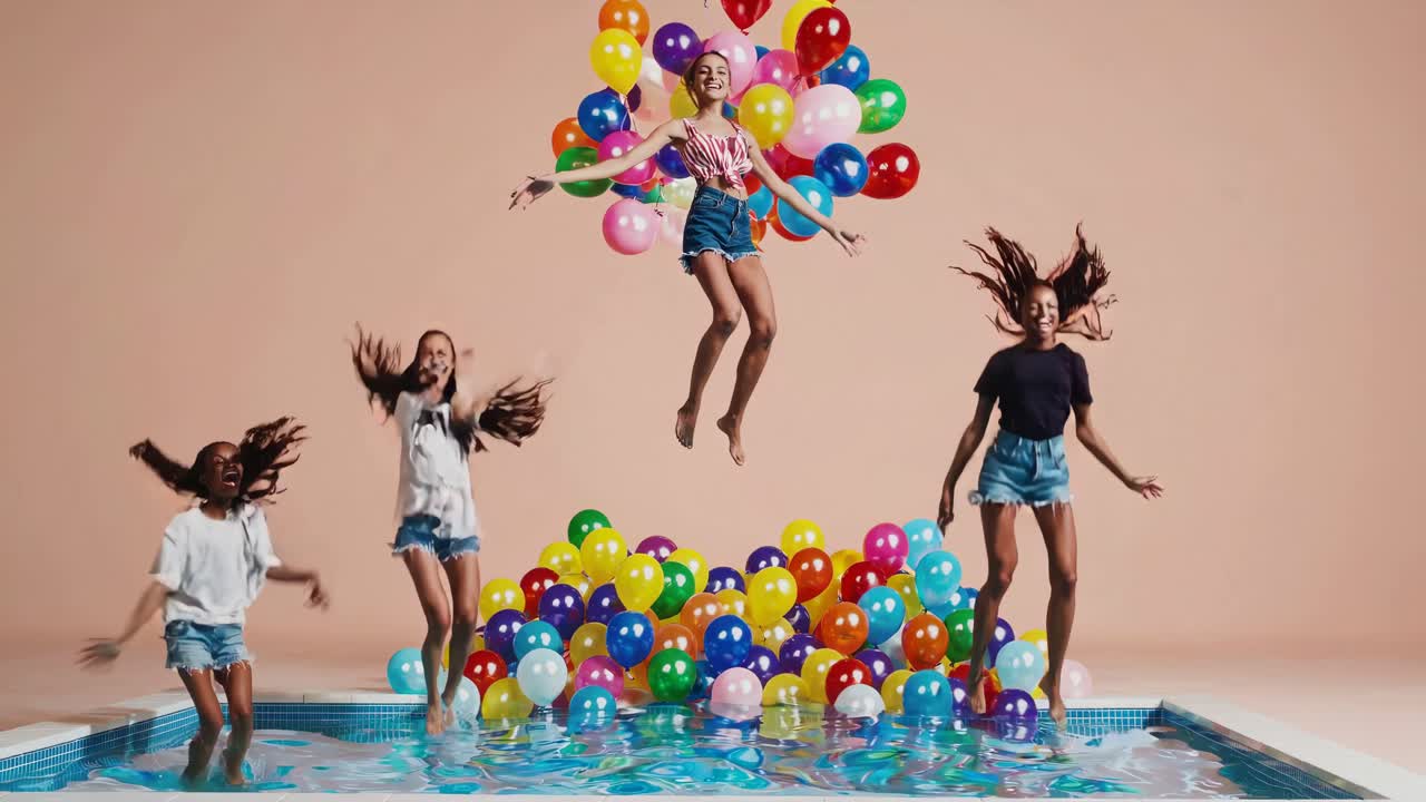 chicas saltando en una piscina con globos