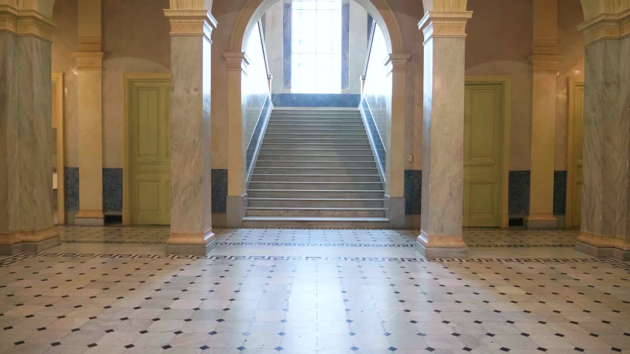 enorme sala de la villa de mármol con columnas y escalera soleada