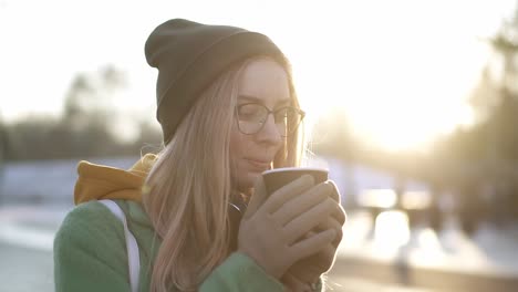 relaxful woman drinking a hot drink, steam from hot coffee or tea