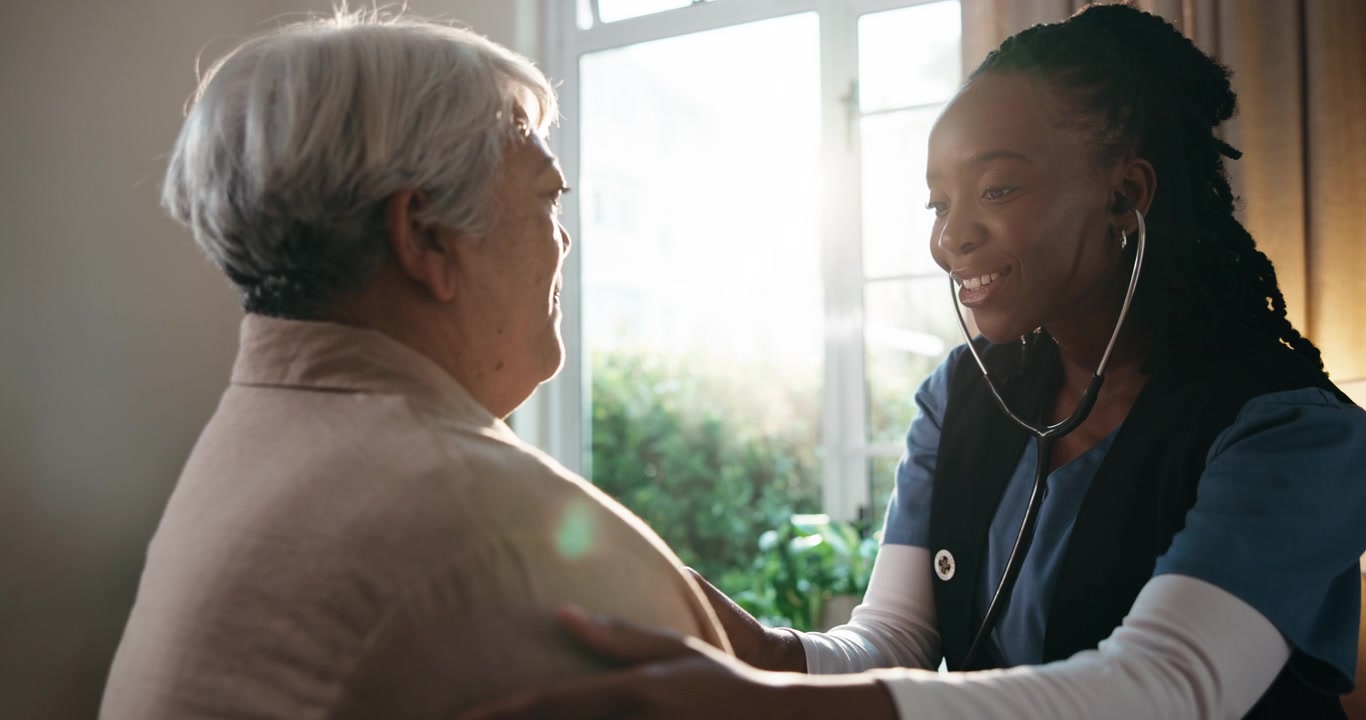 Young Nurse Examining Senior Patient with Stethoscope at Home