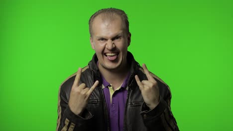 rocker man showing rock and roll sign, devil horns gesture, looking with crazy expression