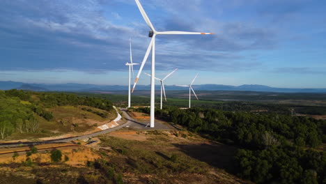 cuatro turbinas eólicas gigantes con hélices girando lentamente en el fondo del viento con cielo azul en el sur de vietnam