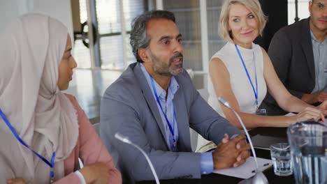 un panel de delegados de negocios hablando en una conferencia