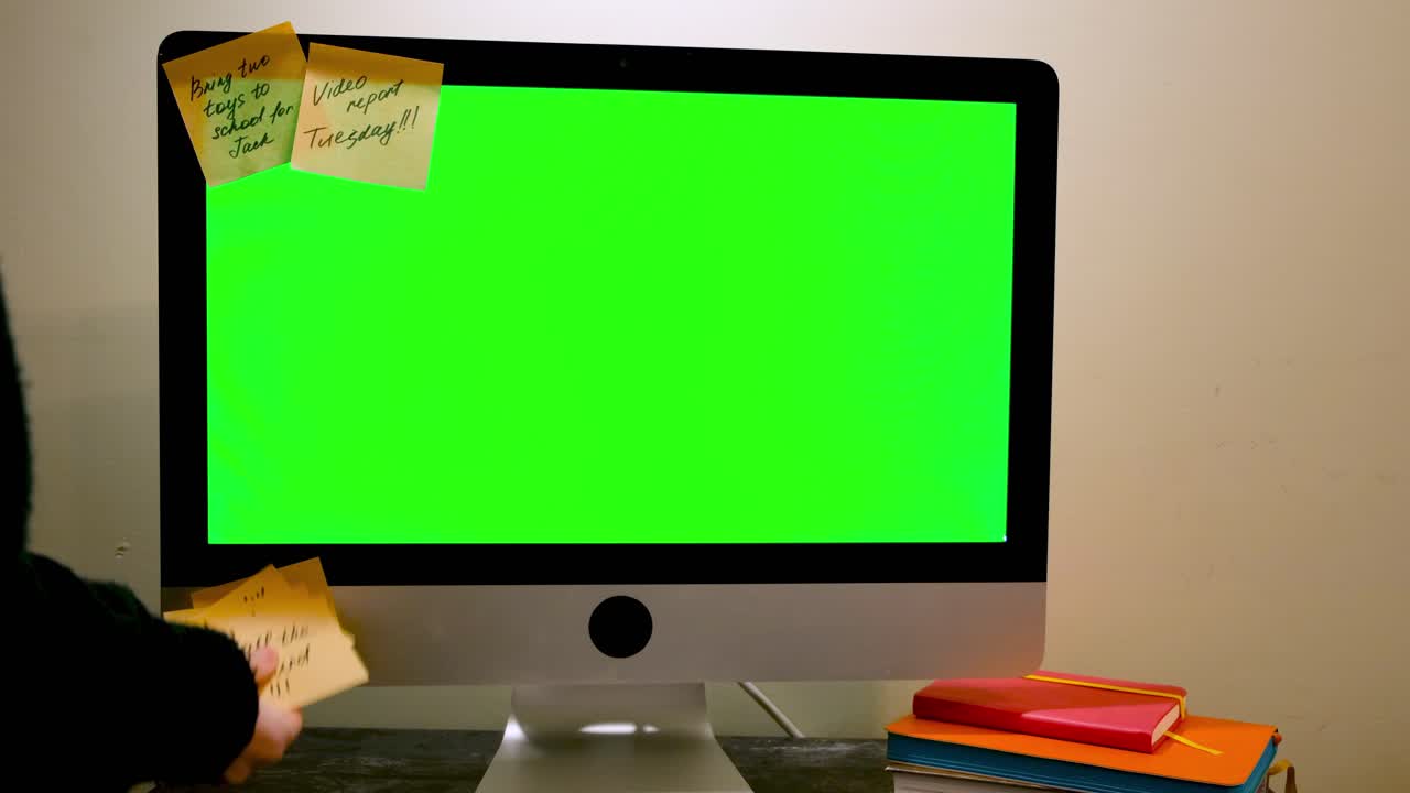 persona que trabaja en una computadora con notas adhesivas