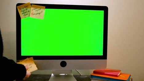 person working on a computer with sticky notes