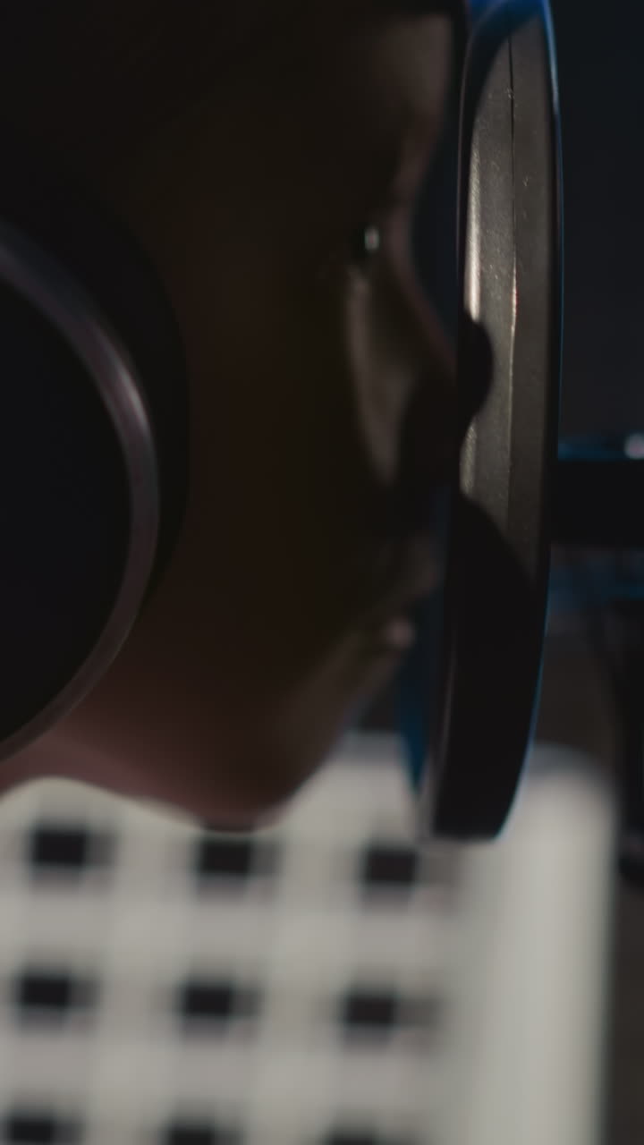 Girl gazes through mic filter at audio studio. Mischievous little girl engages with audio equipment in music center. Kid exhibits signs of fatigue