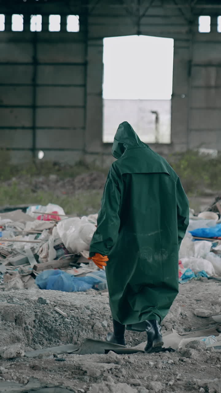 Man in protective mask and suit. Human in biohazard uniform standing in the empty city. Vertical video