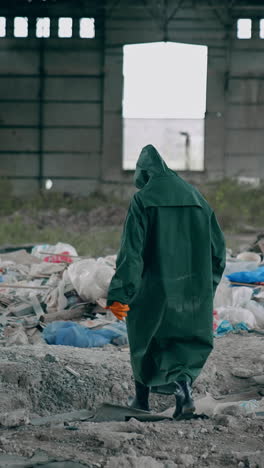 man in protective mask and suit. human in biohazard uniform standing in the empty city. vertical video