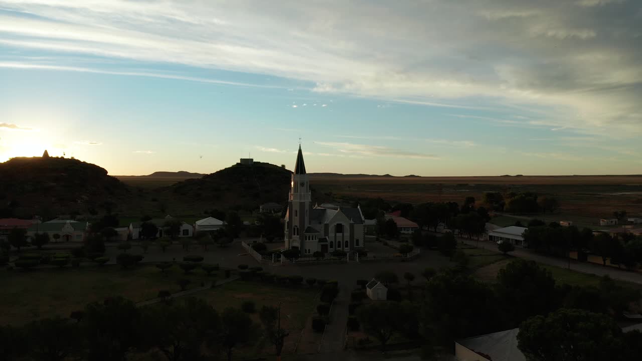 Sun appears from a small hill near the town of Hanover, aerial flying backwards