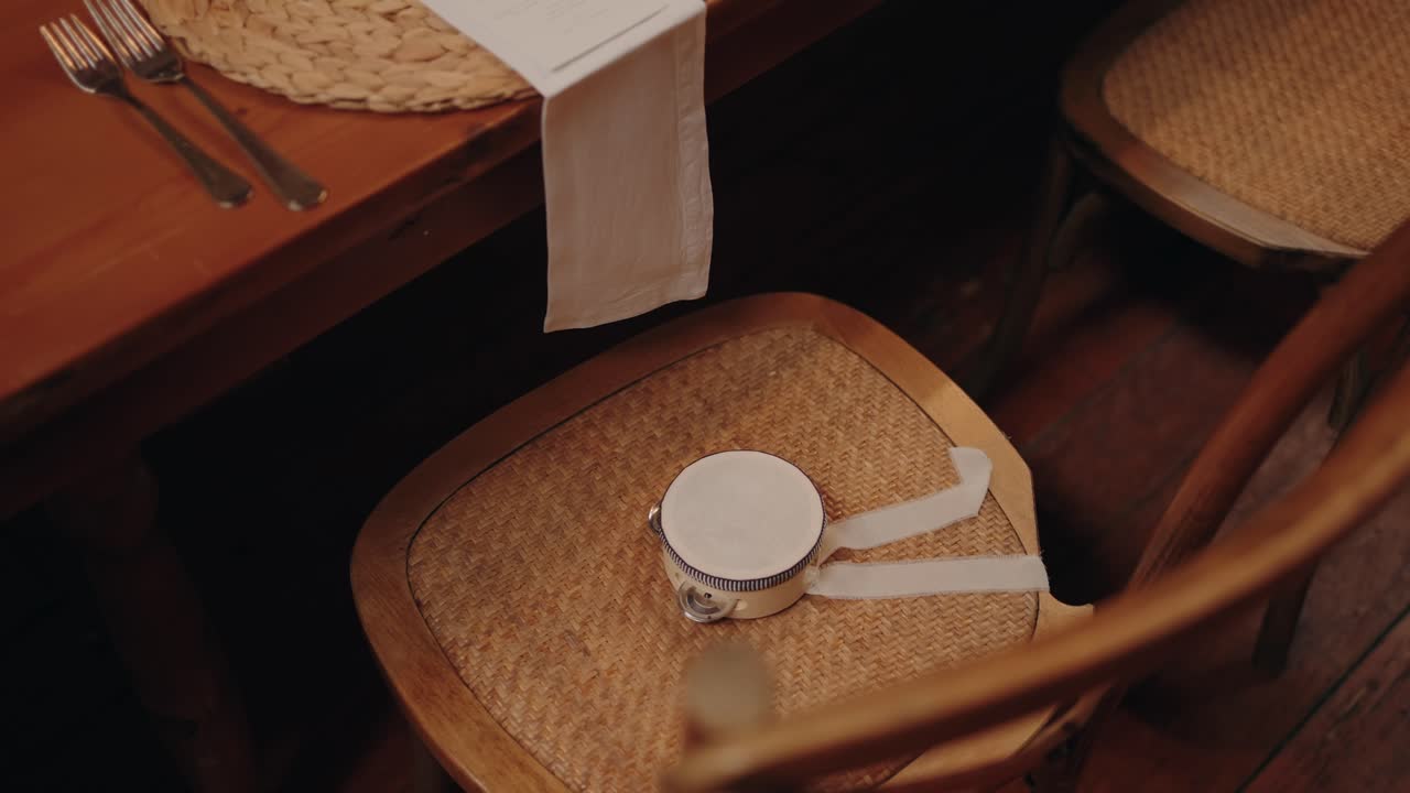 Mini tambourine placed on wooden chair beside banquet table