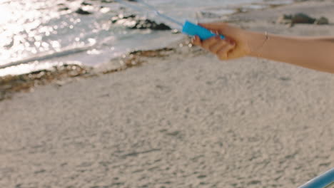 une femme soufflant des bulles à la main sur une plage ensoleillée profitant de vacances d'été ludiques