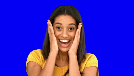 Surprised-woman-holding-her-head-on-blue-screen