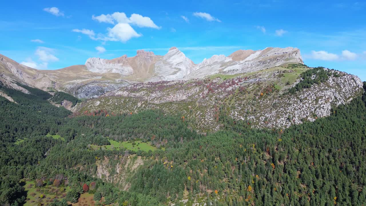 Majada de gabardito with lush forests and rugged mountains under a clear sky, aerial view