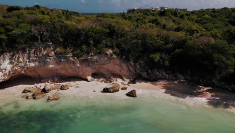 aerial pullback reveals secret beach with caves