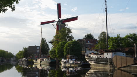 vista panorámica del molino de roode leeuw en turfsingel con barcos antiguos anclados en gouda, países bajos