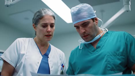 intense medical consultation: surgeons analyzing critical patient information in an operating room setting for optimal decision-making