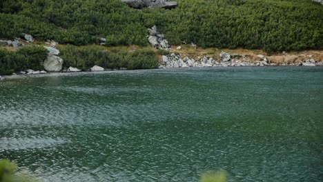 Inclinación-Cinematográfica-Hacia-Arriba-Para-Revelar-Un-Lago-Con-Olas-Azotadas-Por-El-Viento-En-Las-Tierras-Altas-De-Sliezsky-Dom,-Altos-Tatras,-Eslovaquia