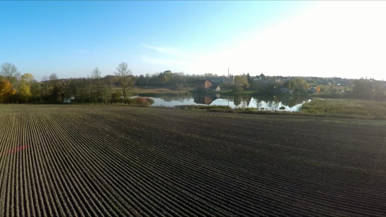 filas de tierras agrícolas y el reflejo de la casa del molino de ladrillo rojo en el río-1