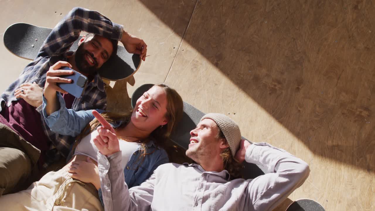 행복 한 다양한 여성 과 남성 스케이트보더 들 이 스케이트 파크 에서 셀카 를 찍는 영상