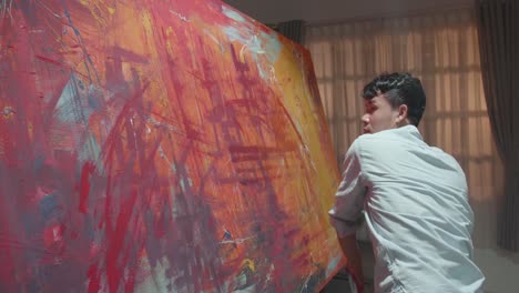 talented male artist energetically draws with paint brush
