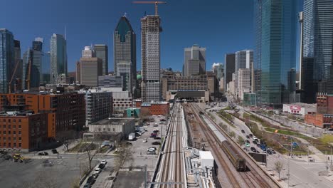 Drohne-Enthüllt-Stadtbild-Von-Montreal,-Kanada,-Quebec,-Mit-U-Bahn-Zug,-Der-Durch-Malerisches-Stadtbild-Mit-Skyline-Der-Metropole-Fährt,-Grüne-Energieinfrastruktur-In-Smart-City