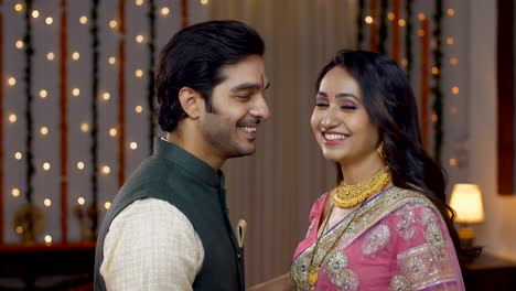 young indian couple happily smiling looking into the camera in traditional wear