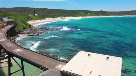 Old-abandoned-coal-loading-pier,-Catherine-Hill-Bay-coast-Australia,-aerial-view