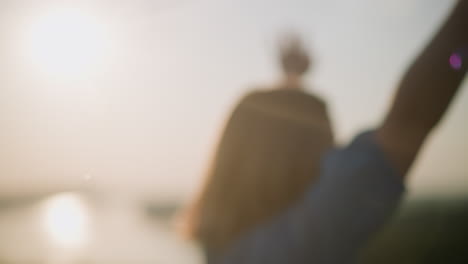 una mujer girando bajo el sol brillante, su figura ligeramente borrosa mientras alegremente se extiende en el aire, rodeada de burbujas flotantes que brillan en la cálida y dorada luz de la puesta de sol