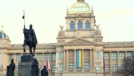 statue and national museum in prague with czech and ukrainian flags