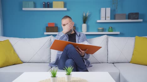 Businessman-examining-work-file-at-home-and-getting-angry.