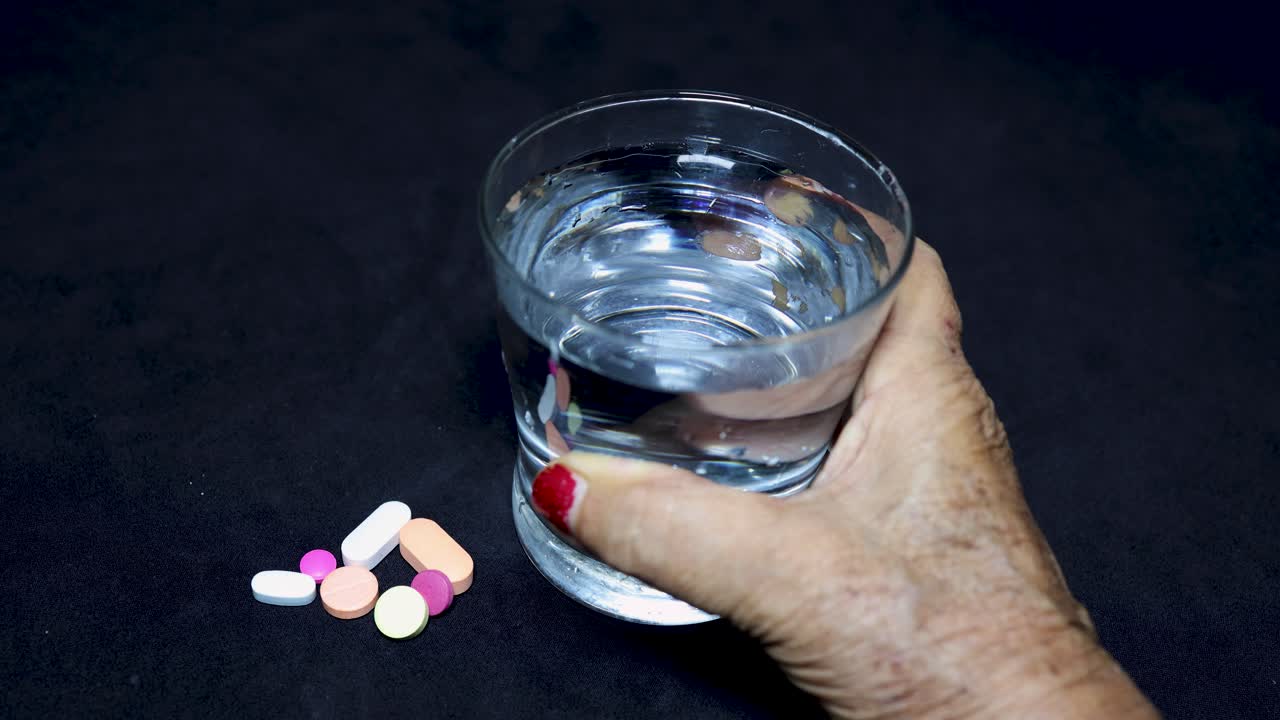 old age health care concept with medicine and water glass