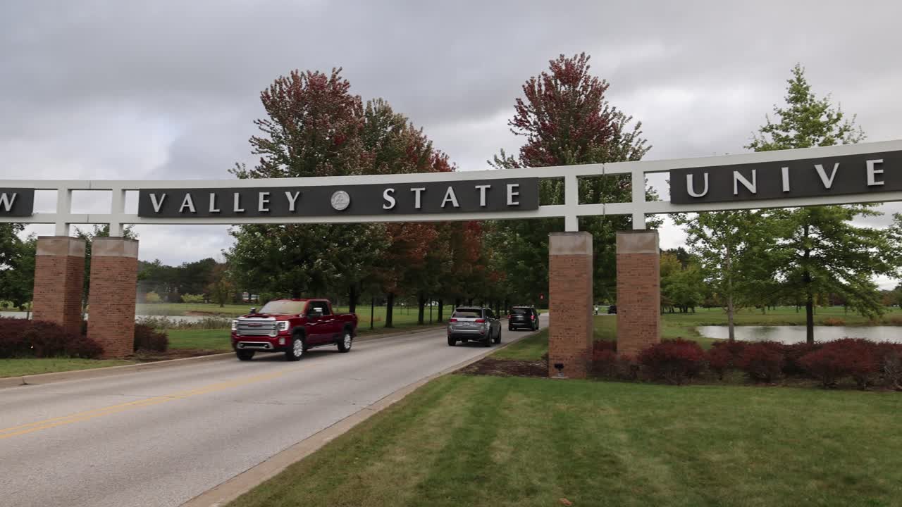 미시간 주 대학 센터에 있는 사기나우  ⁇ 리 주립 대학교 캠퍼스에 운전하는 자동차들과 함께 들어오는 입구