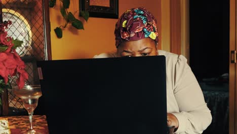 mujer negra buscando atentamente en internet en una laptop