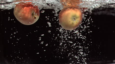 manzanas moviéndose bajo el agua en súper cámara lenta