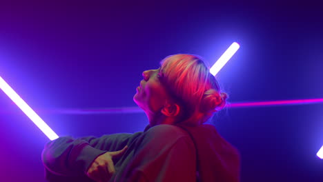 happy girl making hip-hop movements in neon closeup. woman performing freestyle.