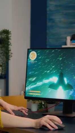 vertical video: expert woman gamer playing space shooter video game