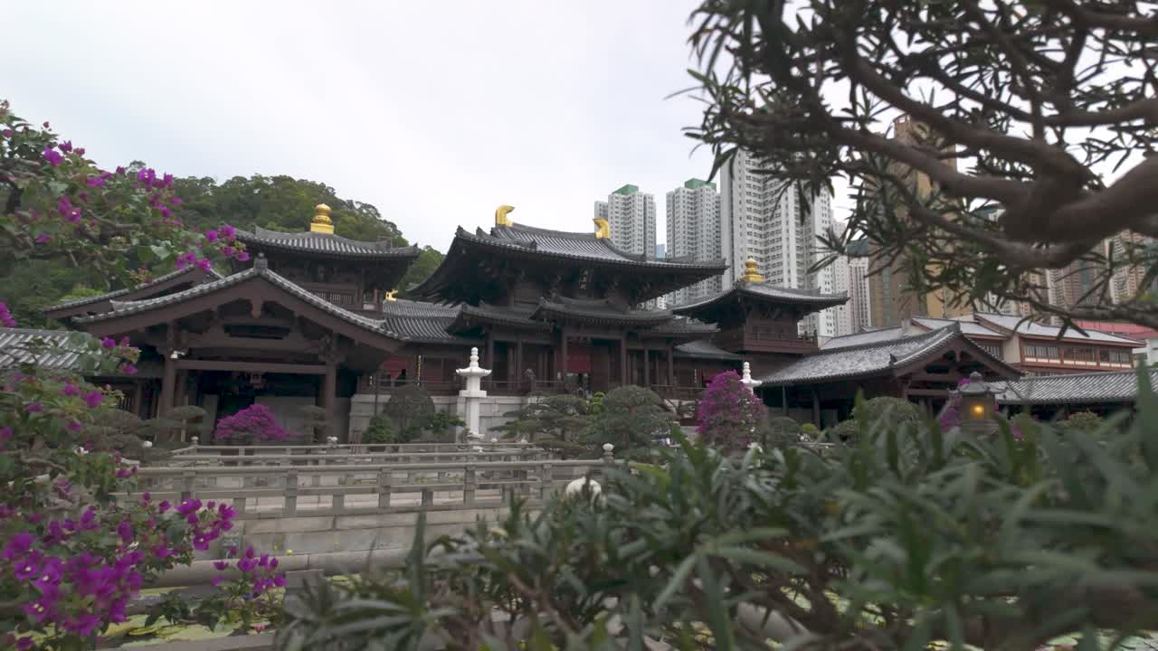 Peaceful traditional complex contrasting with modern residential skyscrapers in Kowloon, Hong Kong, filmed in slow motion