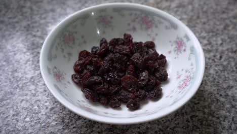 Bowl-Of-Black-Raisins-On-The-Table