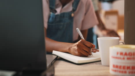 ecommerce, laptop and black woman writing notes