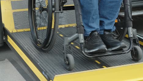 a man in a wheelchair on a lift of a vehicle for people with disabilities. lifting equipment for people with disabilities - man in wheelchair near the vehicle