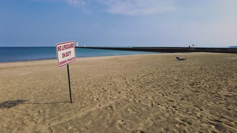 no lifeguard sign on an empty beach at sodus point new york vacation spot at the tip of land on the banks of lake ontario