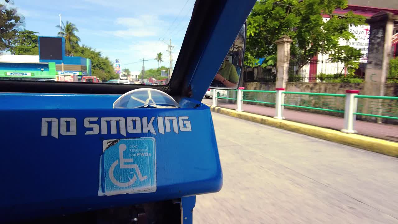 A passenger-side ride on a Jeepney for public transportation. They are known for their crowded seating and kitsch decorations, which have become a widespread symbol of Philippine culture and art.