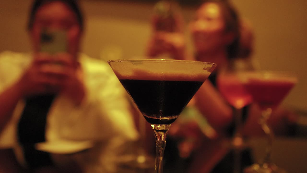 amici che si godono i cocktail e scattano foto