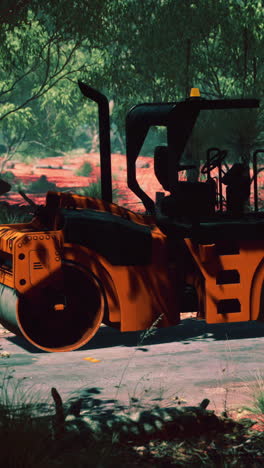 orange road roller in a rural setting