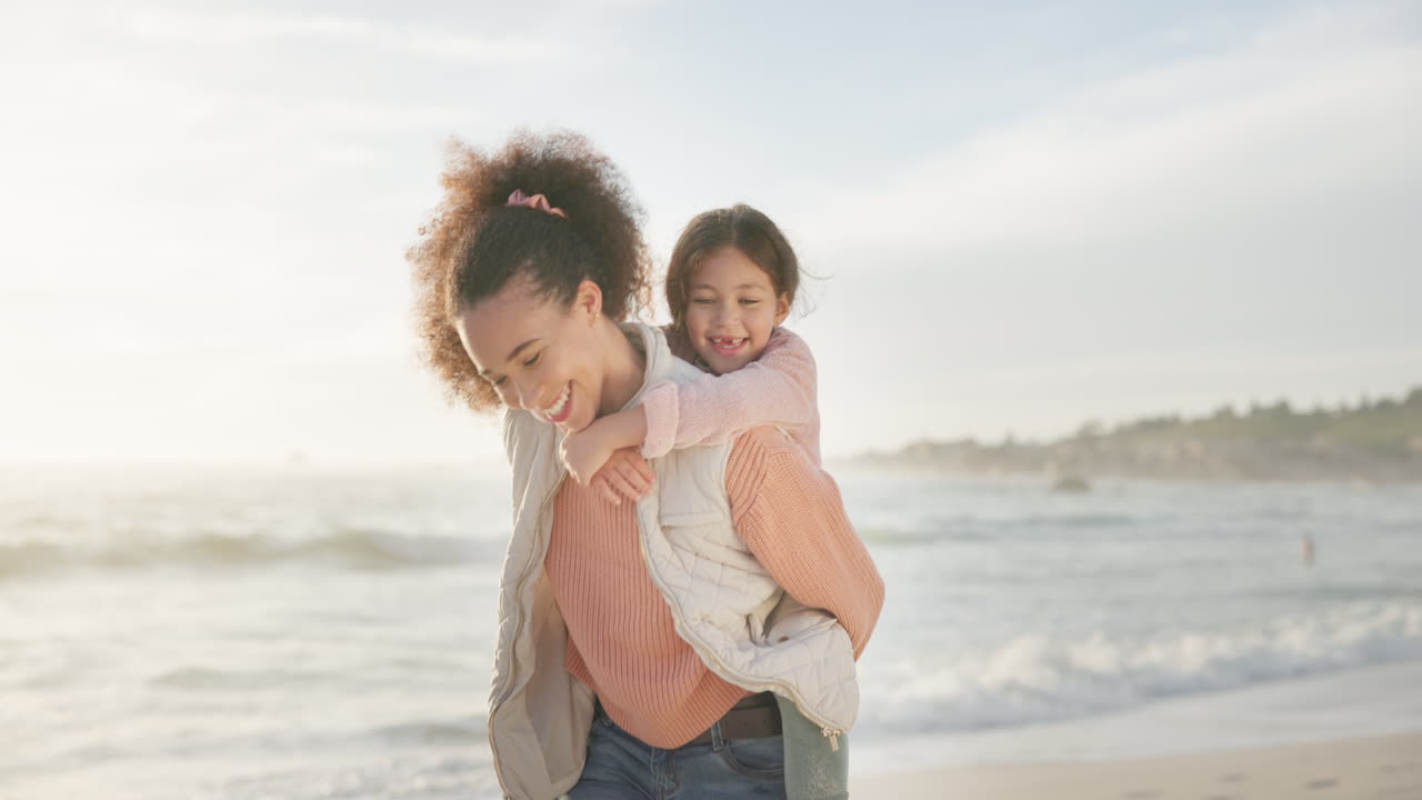 niño, madre y piggyback en la playa