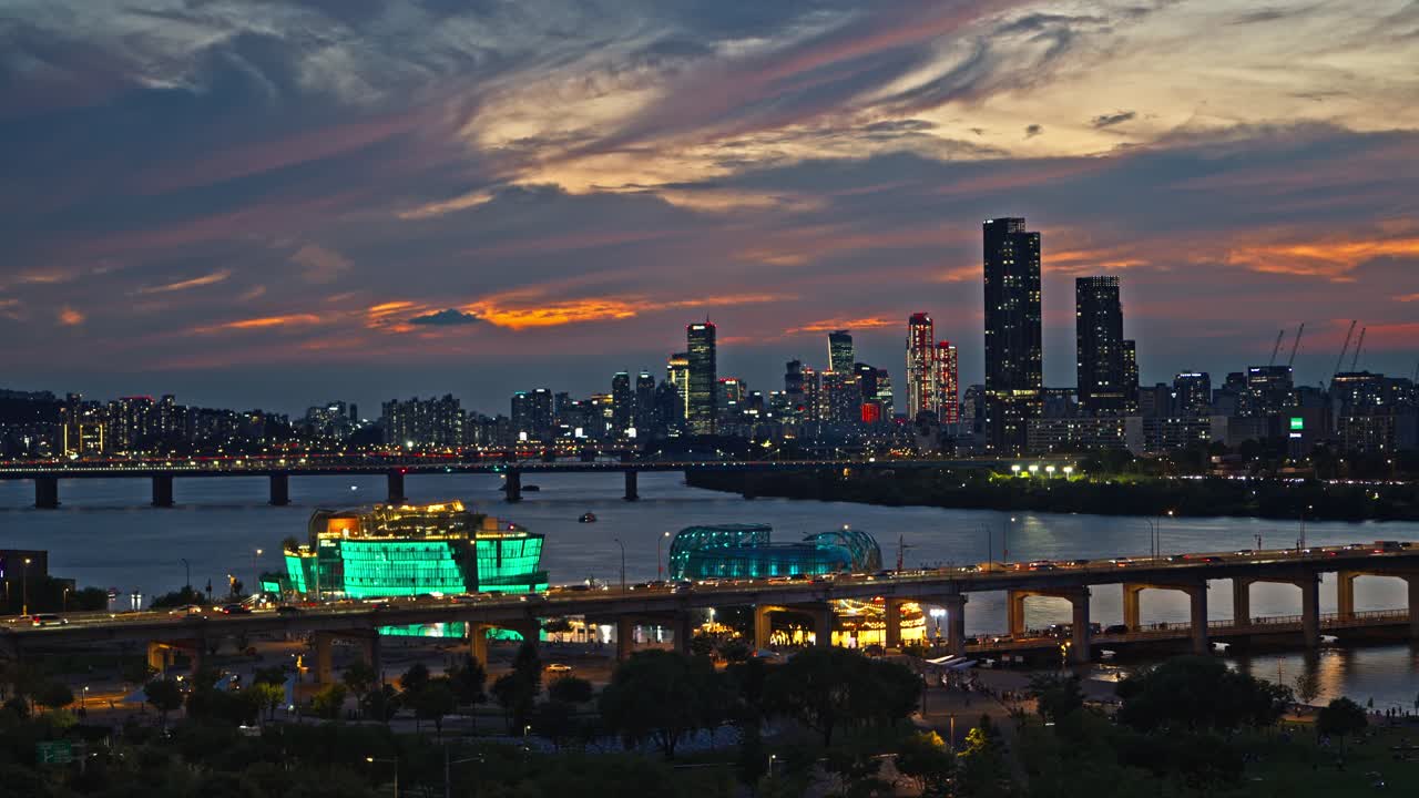 Seoul Banpo Bridge with busy traffic at sunset, Han River skyline view featuring glowing Sevit Island and Sebitseom city lights