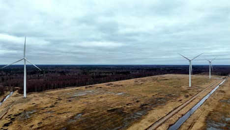 Campo-De-Tiro-Panorámico-En-órbita-Aérea-Con-Tres-Turbinas-Eólicas-En-El-Fondo