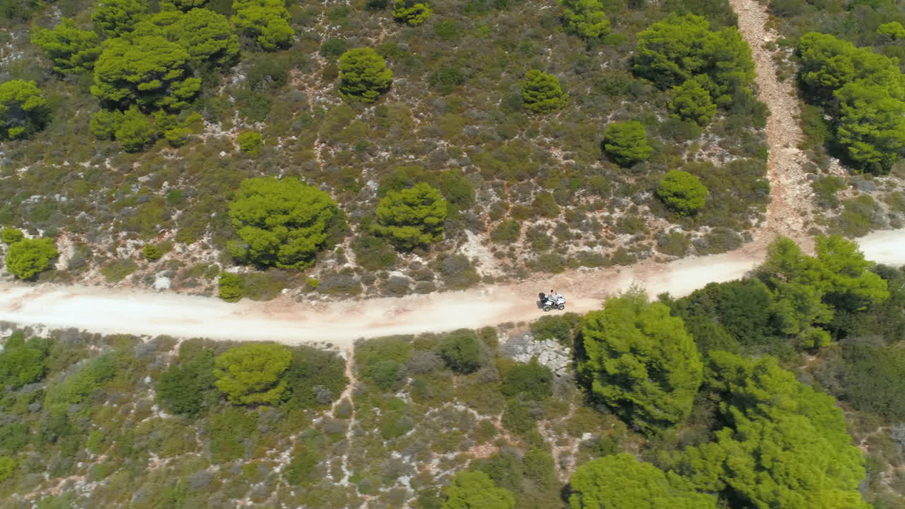Aerial View of ATV Riding on Dirt Road through Lush Forest